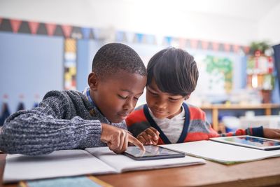 Zwei Jungen tippen auf Tablet im Klassenzimmer .jpg KI-generiertes Bild