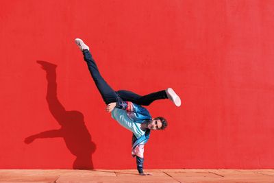 Mann macht Stunt vor roter Mauer .jpg KI-generiertes Bild