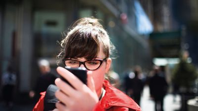 Fraumit Brilleschaut aufSmartphone.jpg KI-generiertes Bild